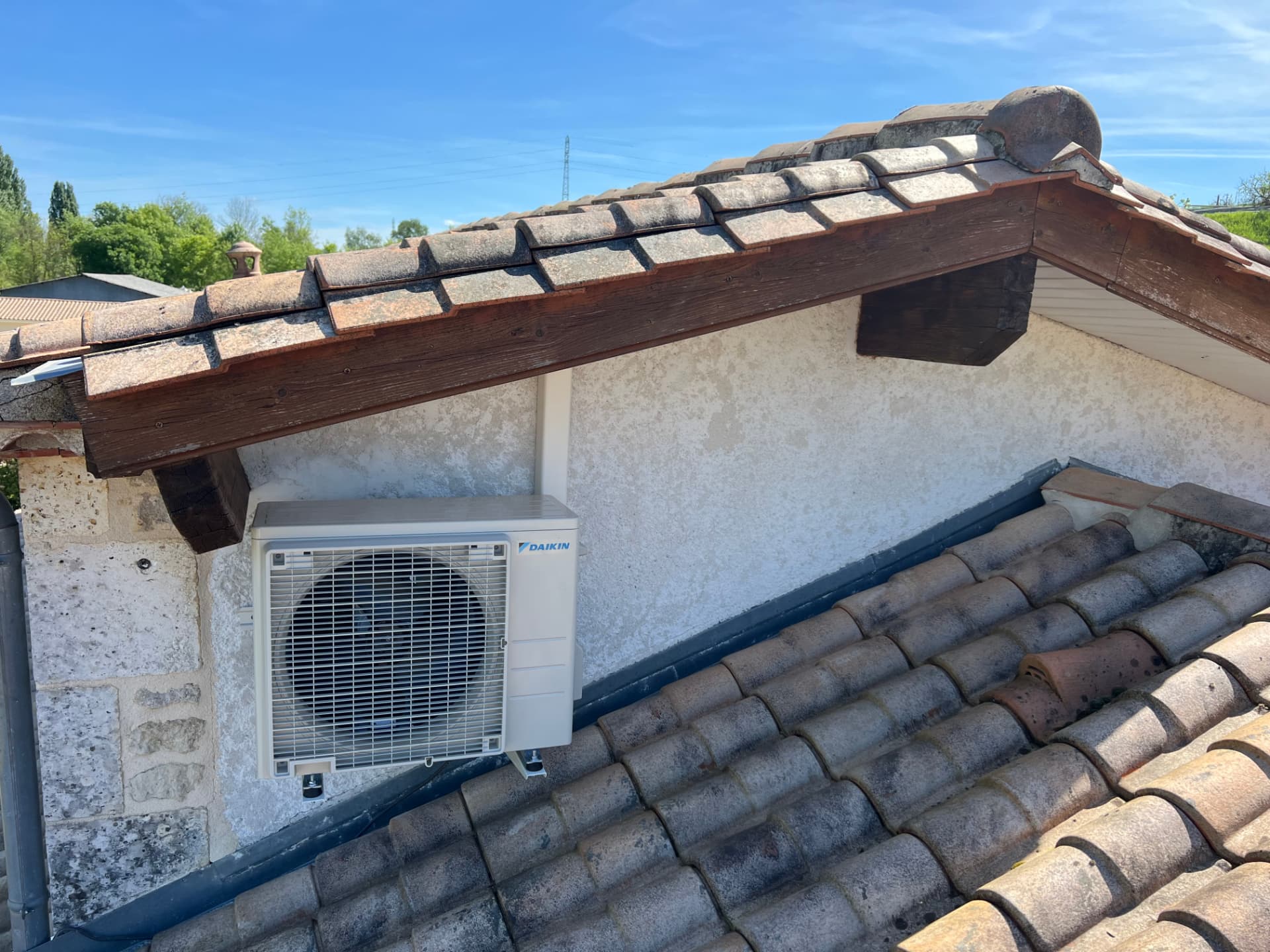 Unité extérieure Daikin fixée sous un débord de toit